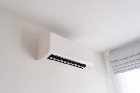 Air conditioner on white concrete wall in area of room space.の写真素材