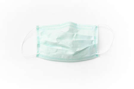 Surgical mask with rubber ear straps isolated on white background. White mask to cover the mouth and nose. Procedure mask from bacteria.の写真素材