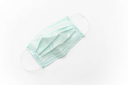 Surgical mask with rubber ear straps isolated on white background. White mask to cover the mouth and nose. Procedure mask from bacteria.の写真素材