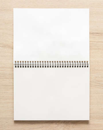 Blank spiral bound notepad mockup template on wood background. High resolution.の写真素材