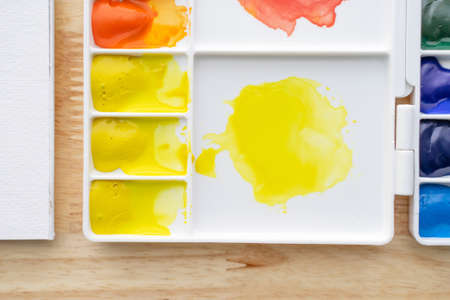 Watercolor paints in white watercolor palette. Bright multicolored aquarelle paints in paint box.
