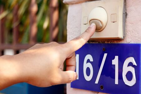Delivery man pressing doorbell.の写真素材