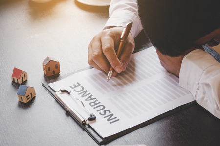 Businessman dismal about home insurance.の写真素材