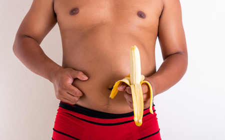 Man pinching her fat and banana. Health care concept.の写真素材