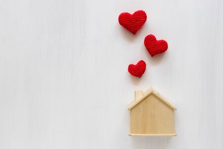 Home saving with Heart made of red yarn on white background. Home insurance concept.の写真素材