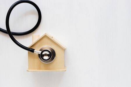 Home saving and stethoscope on white background. Home insurance concept.の写真素材