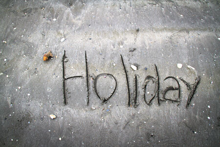 Holiday written in sand.の写真素材