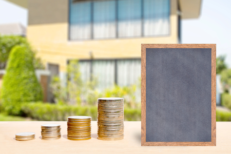 Business finance and real estate concepts, Money coin stack with chalkboard free space for you planing, Blurred home garden background.の写真素材