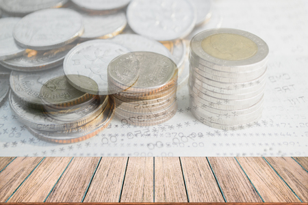 Double exposure of money coins stack for finance and banking concept, Empty wood table top, perspective wood can be used for display products.の写真素材