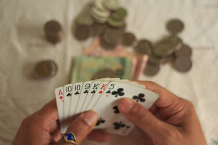 A man playing poker and checking his cardsの写真素材
