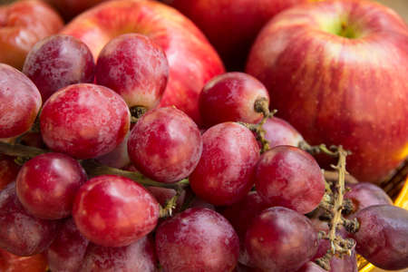 Close up of a large cluster of red grapes and appleの写真素材