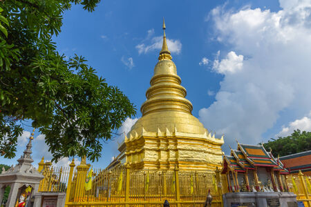 The golden pagoda with blue sky at Hariphunchai temple, Lampang Province, Thailand .の写真素材