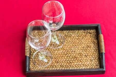 two glass on wicker basket with red  backgroundの写真素材