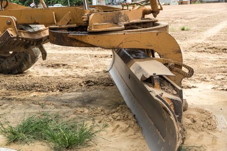 yellow tractor  with plow in the field on build residential areaの写真素材