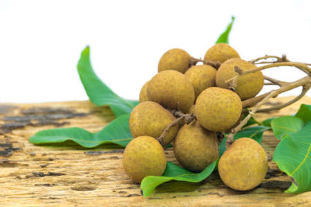 Fresh ripe longan fruits and leaves on a wooden boardの写真素材
