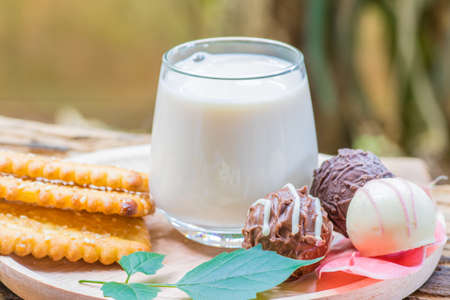 Chocolate and milk is placed on a wooden board.の写真素材