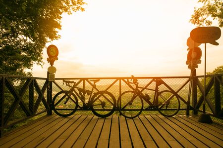 Beautiful sunset view with a mountain bike at the top of a hillの写真素材