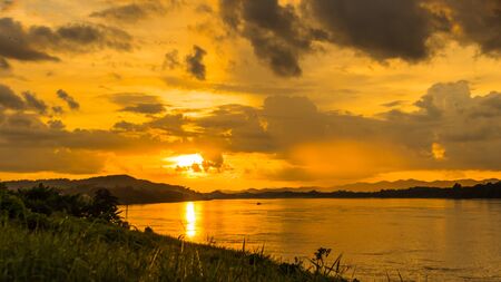 Natural Sunset Sunset. Bright Dramatic Sky And Dark Ground. Countryside Landscape Under Scenic Colorful Sky At Sunset Dawn Sunrise. Sun over Skyline. Warm Colours.の写真素材