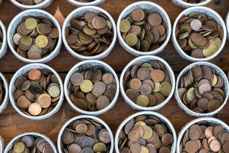 The coin in monk's bowl or almsbowl, Selective focused coins in old monk's alms-bowl, Coin in statue...