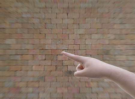 hand pointing at something on brickwall background filterの写真素材