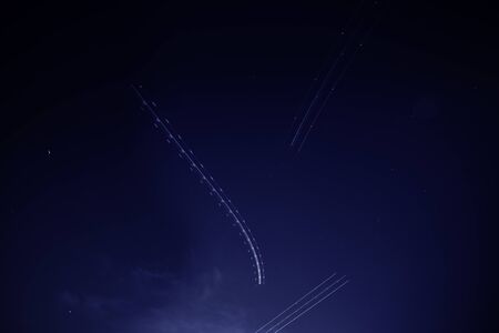 Multiple flying Airplane light trails blinking in the dark sky long exposure photography