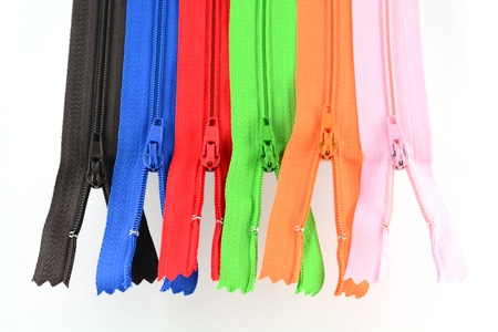 zippers of many colors on a white background の写真素材