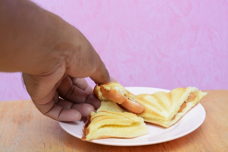 hand with bread Sausage in morningの写真素材