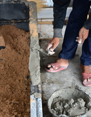 construction mason worker bricklayer making a brickwork with trowel and cement mortar 
の写真素材