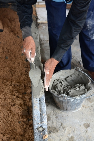 construction mason worker bricklayer making a brickwork with trowel and cement mortar 
の写真素材