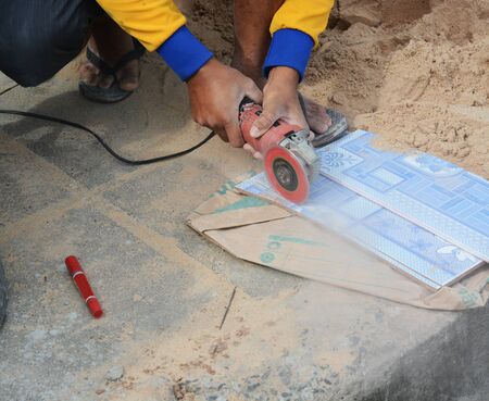 grinder worker cuts a stone the electric tool worker is tiling at home, tile の写真素材