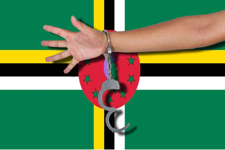 handcuffs with hand on Dominica flagの写真素材
