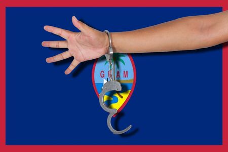 handcuffs with hand on Guam flagの写真素材