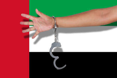 handcuffs with hand on  United Arab Emirates flagの写真素材