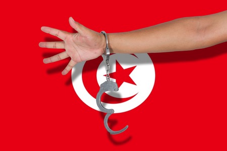 handcuffs with hand on Tunisia flagの写真素材
