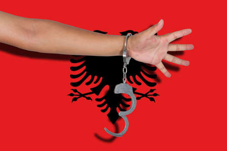 handcuffs with hand on Albania flagの写真素材