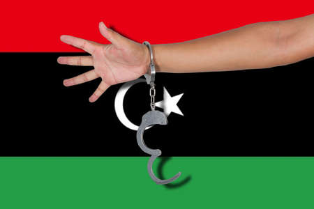 handcuffs with hand on Libya flagの写真素材