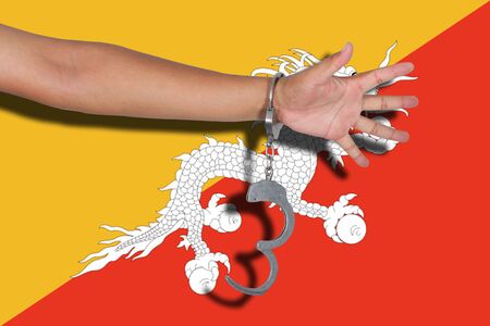 handcuffs with hand on Bhutan flagの写真素材