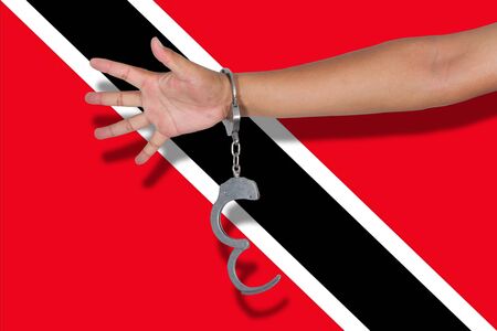 handcuffs with hand on Trinidad and Tobagoh flagの写真素材