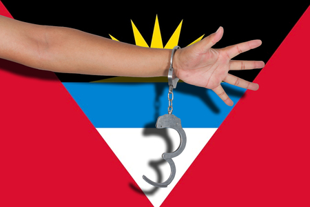 handcuffs with hand on Antigua & Barbuda flagの写真素材