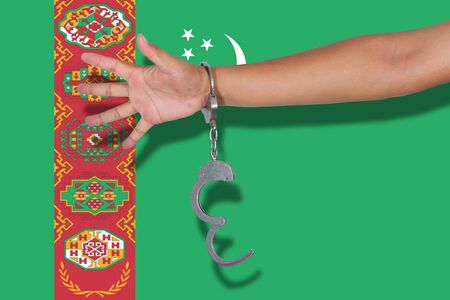 handcuffs with hand on Turkmenistan flagの写真素材