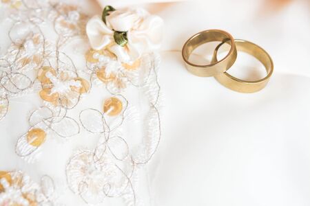Two wedding rings laying on wedding dressの写真素材