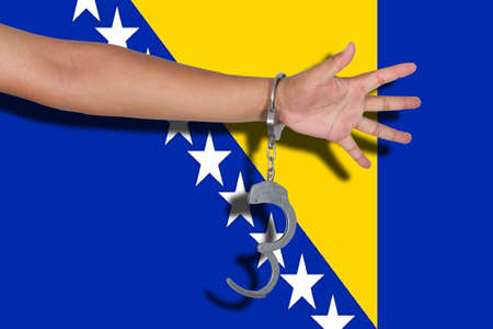 handcuffs with hand on Bosnia Herzegovina flagの写真素材