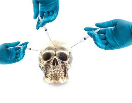 hand inject syringe something to skullの写真素材