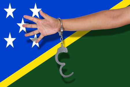 handcuffs with hand on Solomon Islands flagの写真素材