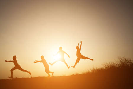 Silhouette Children playing on summer sunset happy timeの写真素材