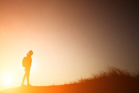 Silhouette woman with backpack walking to travelの写真素材