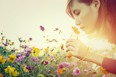 Pretty young woman smelling the flowersの写真素材