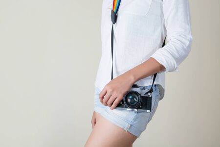 Beautiful young woman photographer holding retro cameraの写真素材