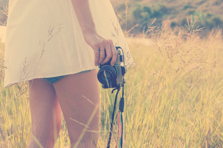 Young woman hand holding retro camera close-upの写真素材