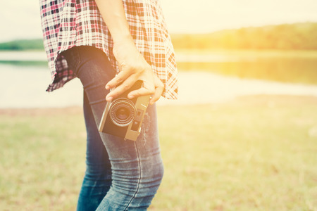 Young beautiful hipster woman holding retro camera outside with nature enjoy fresh air.